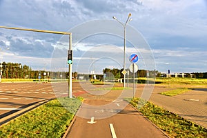 Road sign - the end of cycle path in city at pedestrian zone. Green traffic light signal on a motor road near an intersection and