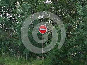 Road sign entry is prohibited stands among the green thickets