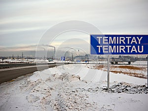 Road sign in front of the city of Temirtau. Smoking pipes