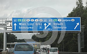 road sign in the highway with cars with directions to the city o photo