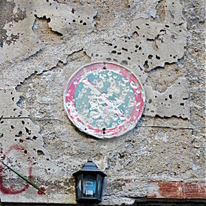 Road sign hit by bullets hanging on the outside wall of a building in the  historic center of Palermo in Italy