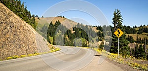 Road Sign Indicates Curves Ahead Mountain Landscape photo