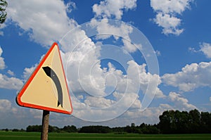 A road sign indicating a left bend in the road.