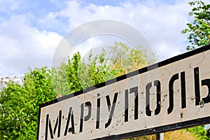 Road sign with the inscription in Ukrainian Mariupol, city of the Donetsk region, punched by bullets, Ukrainian war, conflict East