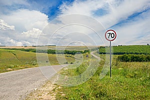 Road sign limiting speed on a country road.