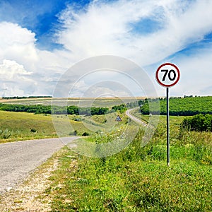Road sign limiting speed on a road. photo
