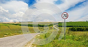 Road sign limiting speed on country road. photo