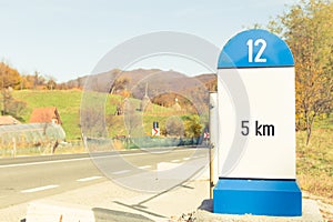 Road sign or milestone showing 5 kilometers to destination