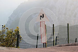 Road sign in the mountains. Warning of winding road ahead