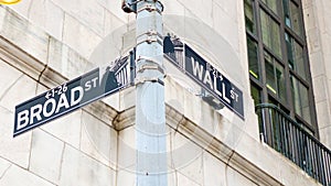 Road sign of New York Wall street corner Broad street.