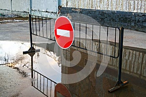 Road sign No entry for vehicular traffic on metal stand in puddle near building photo