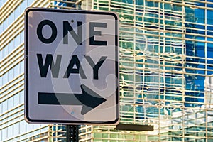 Road sign `One way` on the background of office building