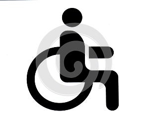 A road sign in the parking lot with the image of a person in a wheelchair. A place for the disabled