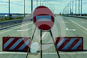 Road sign passage is prohibited, stop and concrete blocks with inclined white and red lines.