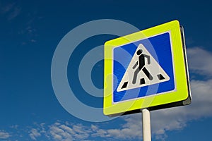 Road sign pedestrian crossing against the blue sky