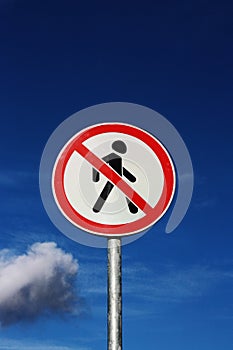 Road sign pedestrians are forbidden to pass with the sky