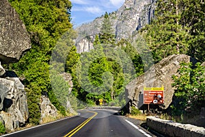 Road sign posted on Highway 120 with stop ahead warning and directions; Yosemite National Park, Sierra Nevada mountains,