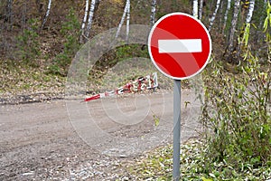 Road sign prohibiting passage at the exit onto a dirt road.