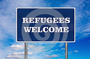 The road sign with Refugees welcome sign