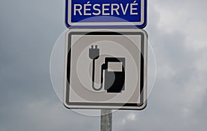 Road sign reserves reservations for electric cars. Charging station with petrol stand symbol with cable and plug for electric batt