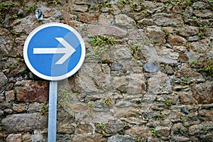 Road sign right arrow on the old stone wall background