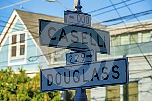 Road sign that says Caselli and Douglass in the downtown historic districts of San Francisco, in shade with white and