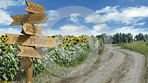 A road sign showing the direction to state capitals standing on a country road