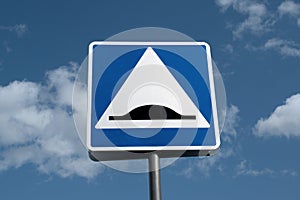 Road sign speed bump on cloud sky background