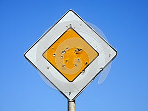 A ROAD SIGN WITH TRACES OF GUNSHOTS