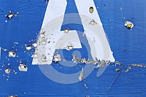 The road sign of the village, in the place of hostilities. Bullet holes in metal