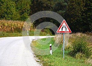 Road sign that warns drivers of constriction on the road