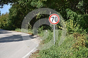 Road sign that warns drivers that maximum speed is 70 kilometers per hour