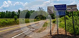 Road signs along with a Welcome to Pennsylvania sign on Akerley Road in Pine Grove Township, Pennsylvania, USA