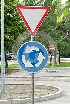 Road signs on a background of trees, give way, roundabout, travel is prohibited