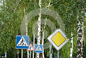 Road signs on a background of trees, main road, pedestrian crossing