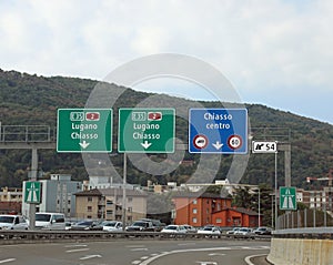 road signs for the cities of CHIASSO and Lugano near  border between Switzerland and Italy