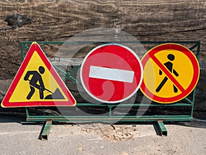 Road signs installed on a metal fence warn of repairs