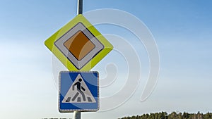 Road signs Main road and Crosswalk on blue sky background. Space for text. Traffic signs main road and pedestrian crossing