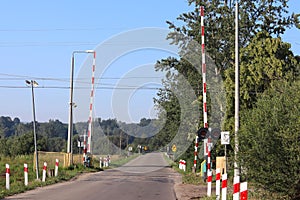 Road signs at the railway crossing with a barrier. Organization of the transport system of a European country. Red white coloring