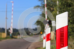 Road signs at the railway crossing with a barrier. Organization of the transport system of a European country. Red white coloring