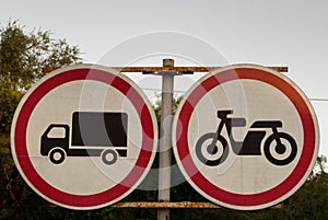 Road signs, road sign on a background of trees, the movement of trucks is prohibited, the movement of motorcycles is prohibited, p