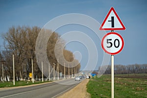 Road signs speed limit 50 km per hour. The road turns left