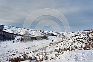 The road between the snow-capped mountains, sometimes covered with forest.