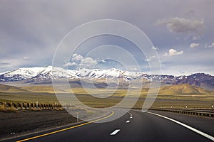 Road and snowcapped mountain peaks