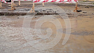 Road spurt water beside traffic cones. Puddle causing damage to asphalt. Sewers