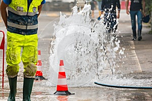 Road spurt water beside traffic cones and a technician photo