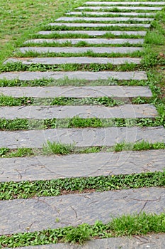 Road stone plates on a green grass