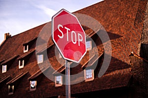 Road stop sign on the road in the city center on a background of red brick building. warning traffic signs