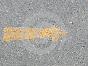 Road surface with yellow arrow sign, outdoor symbol, going forward, left to right, abstract photo
