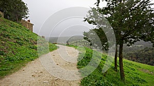 Road that surrounds the city of Pedraza on a very windy and foggy day, Segovia.